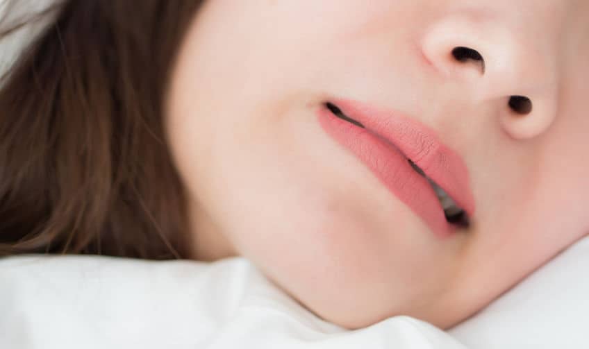 A woman grinding her teeth during sleep