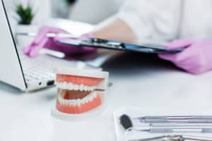 A dentist working on a laptop in a dental office